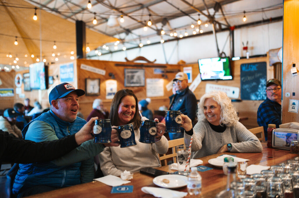 Group of friends cheering glasses at ski bar
